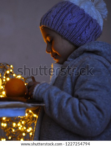 Cute little girl plays with a christmas lights.