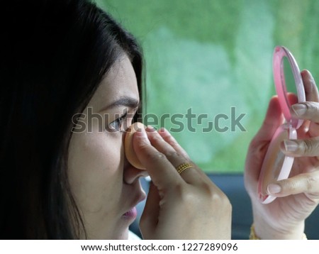 asian woman make-up and looking mirror.