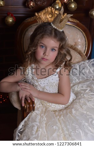 portrait of a little girl princess in a crown in a white dress in christmas