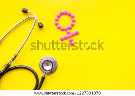 Female diseases concept. Stethoscope near female sign on yellow background top view copy space