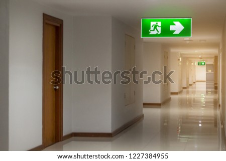 green emergency exit sign in hotel showing the way to escape
