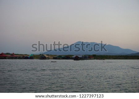 The raft house in the middle of the lake with the mountain background 