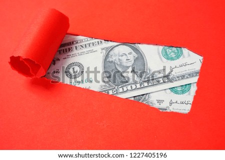 United States Dollars in the gap (hole) of a red background. Dirty money, illegal income. Criminal money.                    
