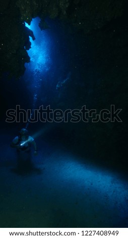 scuba diver exploring cave underwater nice lightning