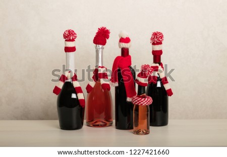Merry Christmas and Happy New Year! Holiday knitted decor - Santa Claus knitted hats on the bottle with wine. Selective focus