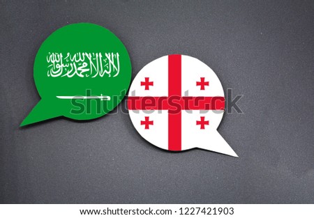 Saudi Arabia and Georgia flags with two speech bubbles on dark gray background
