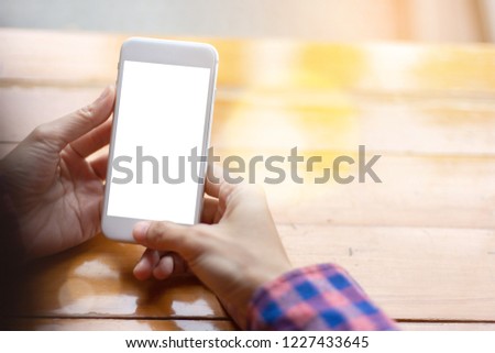 mockup image.woman hand holding texting white cell phone at workplace with concept for electric,communication device research world international modern business,techonology