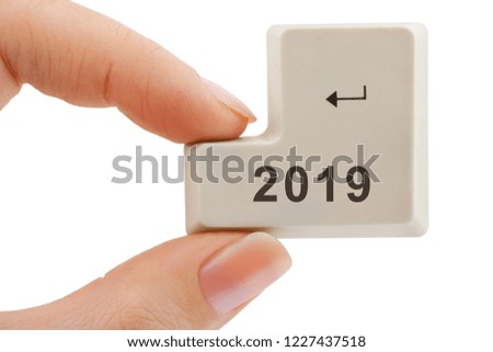 Computer button 2019 in hand isolated on white background