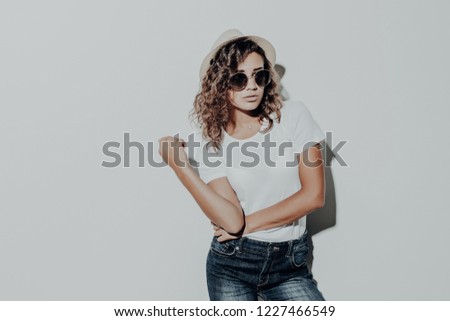 Portrait of curly latin woman in casual summer clothes in brown hat isolated on white background.