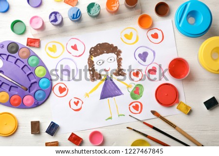 Flat lay composition with child's painting of girl on table