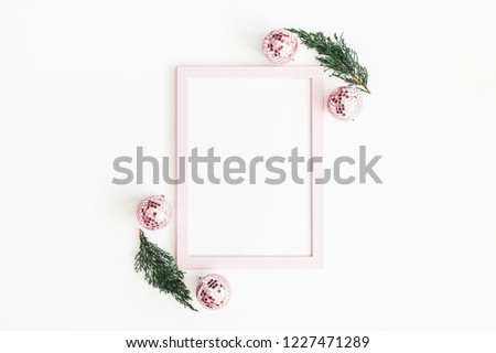 Christmas composition. Photo frame, pink decorations, fir tree branches on white background. Christmas, winter, new year concept. Flat lay, top view, copy space