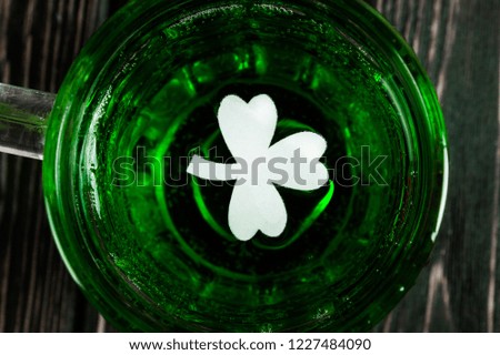 St. Patricks Day green shamrocks with a full cold frosty glass of beer