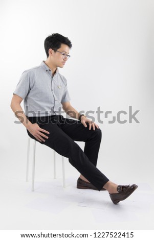 clothes, people, luxury, background, fashion, style concept -   Young asian men sitting on white chair with Gray oxford shirt short sleeve and black slack pants on white background
