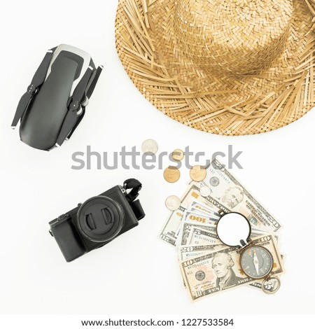 Travel holiday concept with drone, straw, camera, vintage compass and USA cash on white background. Flat lay, top view.