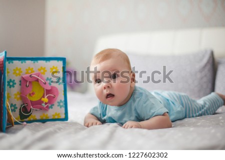 Adorable baby boy. Newborn child relaxing in bed. Family morning at home