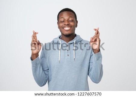 Young african man making a wish isolated on white background. I want to receive all i need.