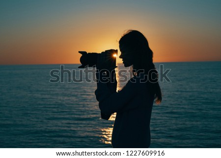 woman silhouette in nature with a camera in hand                             