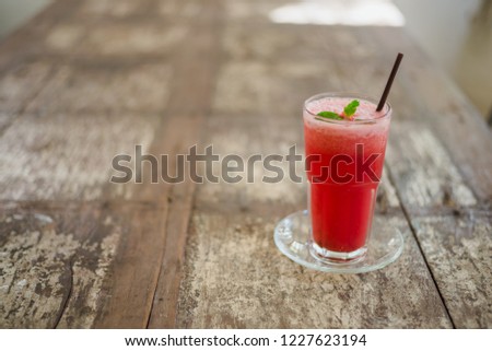 Glass of watermelon juice on wooden table, closeup.