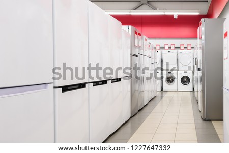 Rows of fridges and washing mashines in appliance store Royalty-Free Stock Photo #1227647332