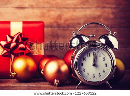 gray metal alarm clock and Christmas gifts and baubles on a wooden table and background
