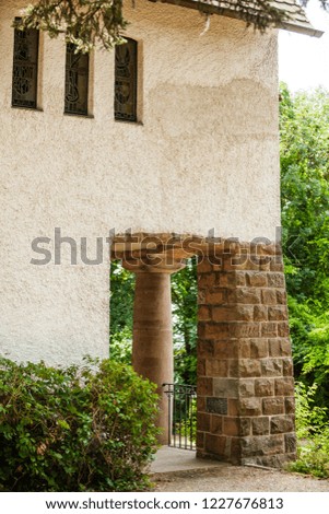 Side of a small church in southern Germany. Entrance with bricks and columns.  