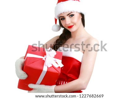Happy woman wearing Santa hat holding gift box. Close up portrait with shoulders.