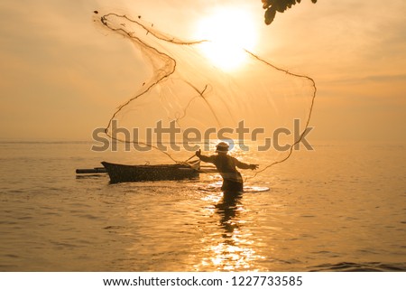 fisherman casting net during sunrise. Fishing and outdoor activities concept. selective focus.