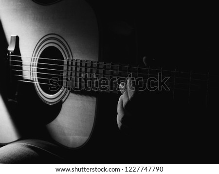 GUITARIST PLAYS ON THE ACOUSTIC GUITAR ON THE STAGE.