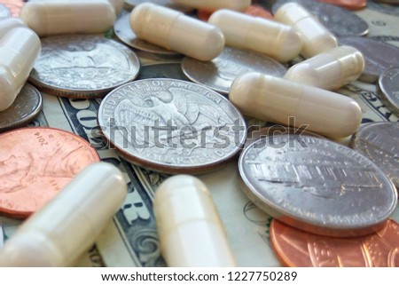 Pills, tablets and capsules with American coins on dollar usa background. Pharmacy and money theme, health care, drug prescription for treatment medication