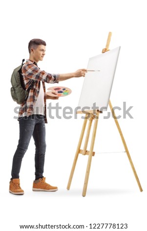 Full length profile shot of a teenage boy painting on a canvas isolated on white background