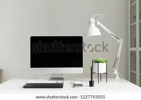 Modern office desk table. Desktop computer, white lamp, graphics tablet, keyboard, mouse, pen and succulent plant. Copy space. Scandinavian home, minimalistic style