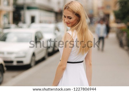 Beautiful blond hair woman in white dress dance in the centre of the city