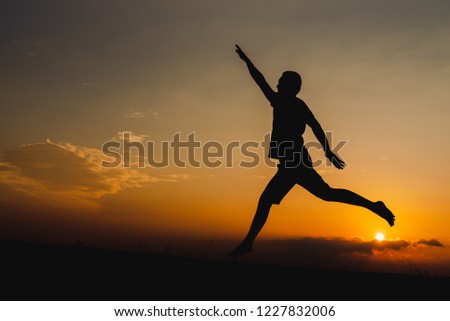 silhouette of man  jump happily with sunset.