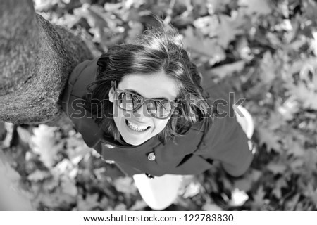 Beautiful smiling girl standing in park on leaves