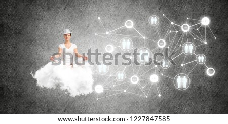 Woman in white clothing keeping eyes closed and looking concentrated while meditating on flying cloud in the air with social network structure on gray dark wall on background.
