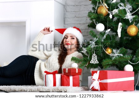 Happy young woman lying on the floor with gift box