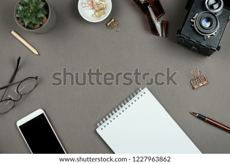 Stylish minimalist mockup with notebook, planner, glasses, pen and vintage camera on grey background with copyspace