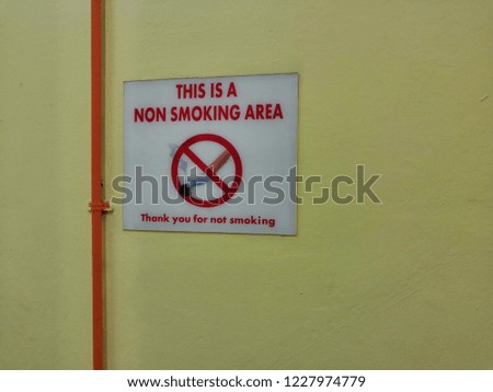 No smoking sign on yellow wall. 
