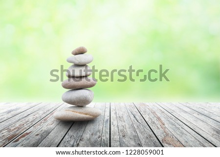 zen stones on empty wooden with green leaf in the garden background blurred and . Concept relaxation, zen, spring. 