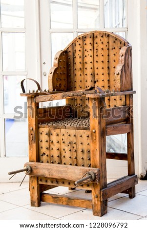 old wooden chair with spikes for torture