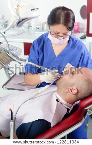 Female dentist doing a medical procedure to her patient