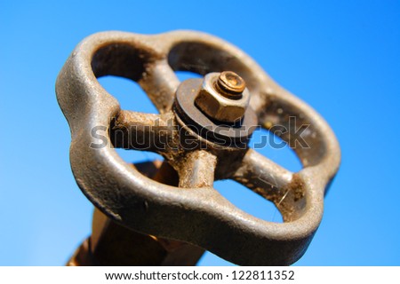 old faucet outdoors on blue sky background