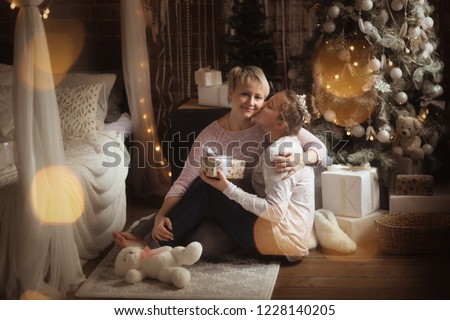 Mom hugs disability teenager's daughter near the New Year tree, concept of New Year and Christmas, transition age.