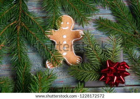 A gingerbread man with Christmas decorations and lots of fir branches. Christmas gift box. Holiday greeting card. Copy spase, spase for text.