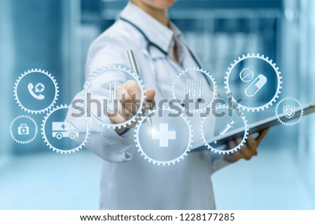 A doctor is operating with cogwheels mechanism containing the medical symbols inside while making notes. The concept is the health service mechanism meaning.