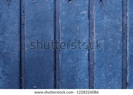 Texture of old wooden door. Blue wooden wall with traces of active use and strong wear. Rich dark blue color for background or screensaver.
