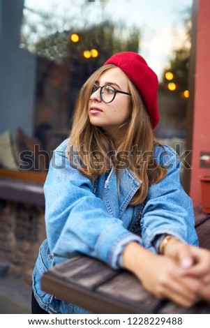 Summer sunny lifestyle fashion portrait of young stylish hipster woman walking on street,wearing cute trendy outfit with red hat ,smiling enjoy weekends.          