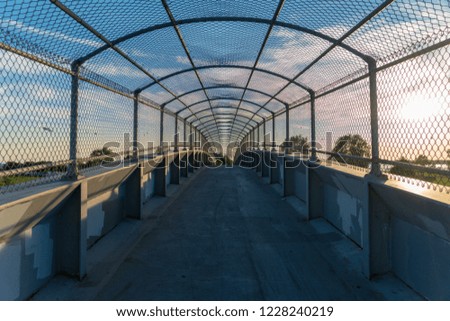 Pedestrian bridge crossing over a highway on the way to a park.