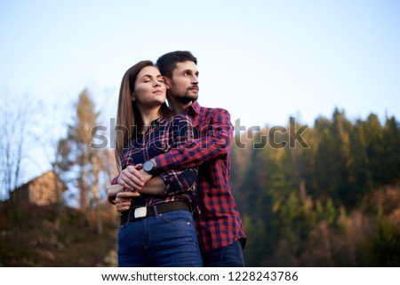Young couple in love hugging in front of mountains and rocks 