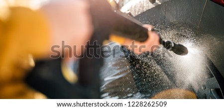 Woman washing her car with pressure washer at home backyard Royalty-Free Stock Photo #1228262509